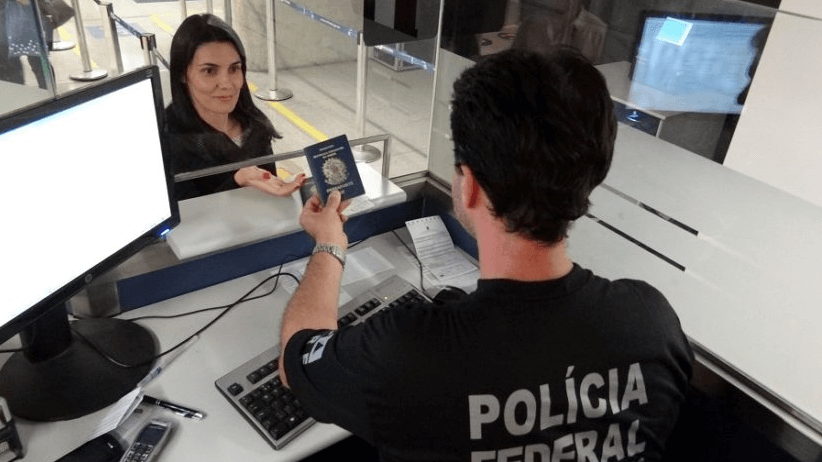 Profissional da Polícia Federal recebendo registro em carteira. 